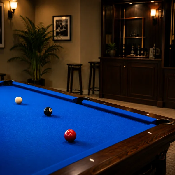 A slate pool table being professionally refelted with green billiard cloth